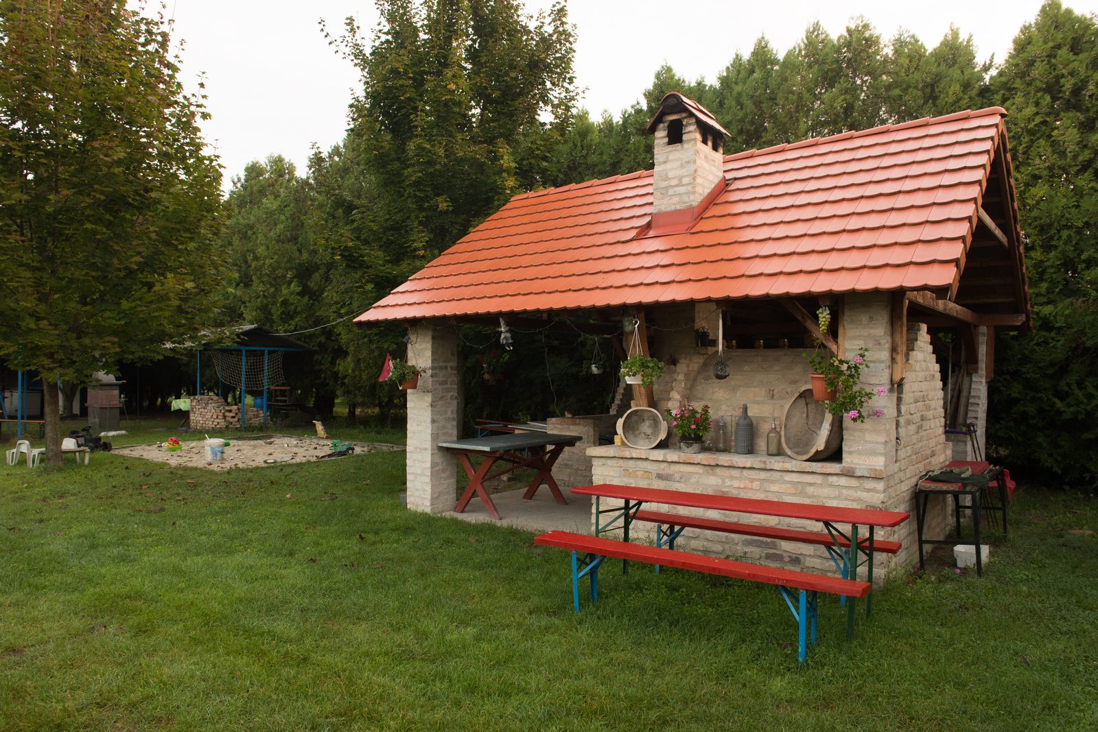 Fedett szabadtéri konyha kemencével a tóparton.